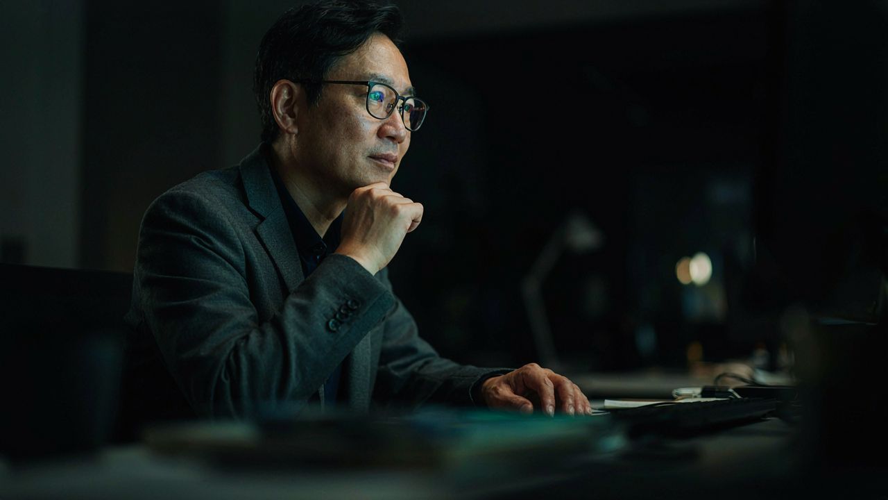 professional man headshot east asian glasses business casual neutral background